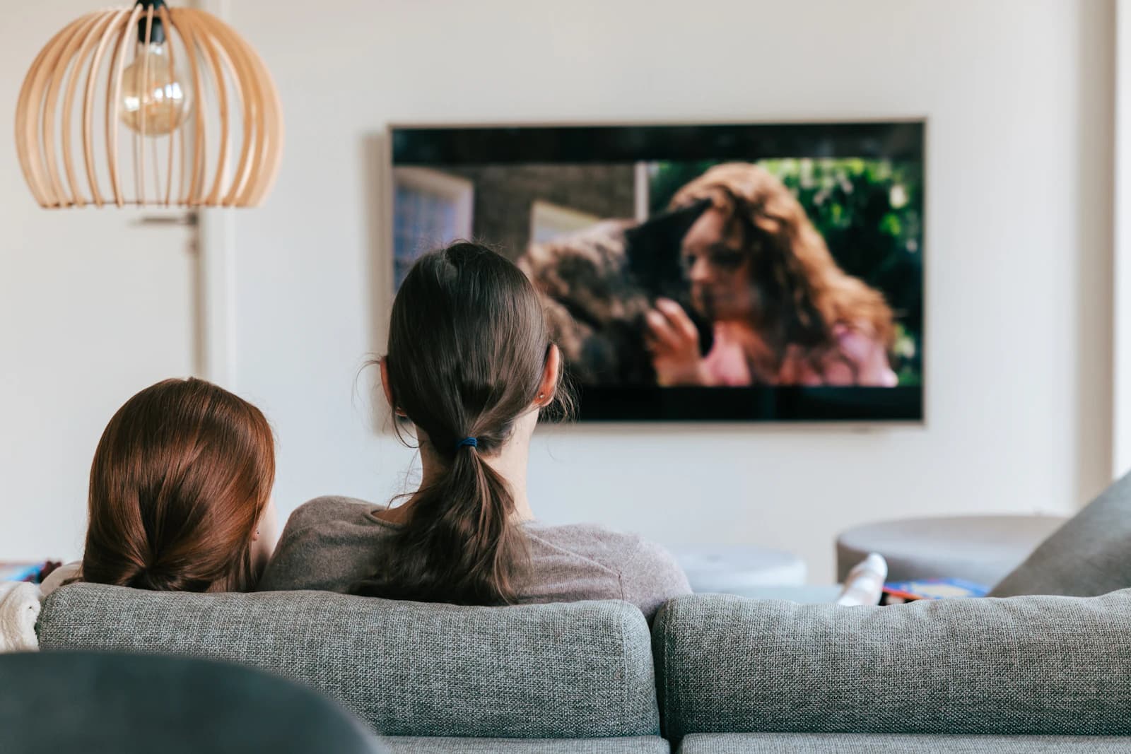 Två vänner som ser en serie i soffan
